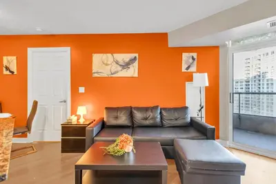 a living room with a couch and an orange wall at 2 bedroom spacious apartment in Mississauga in Mississauga