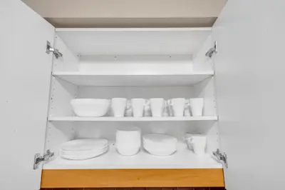 a kitchen with white plates and bowls on shelves at 2 bedroom spacious apartment in Mississauga in Mississauga