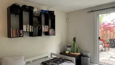 a room with shelves on the wall with a bed at Picturesque 3-story townhouse in Toronto