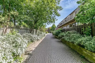 a brick road next to a building with trees and flowers at Picturesque 3-story townhouse in Toronto