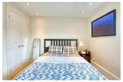 a bedroom with a bed and a tv on the wall at Picturesque 3-story townhouse in Toronto