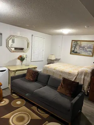 a living room with a couch in front of a bed at Pau-Rae's Cozy Spot - your home away from home! in Thornhill