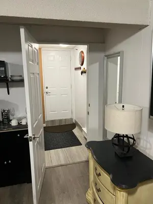 a kitchen with a door and a table with a lamp at Pau-Rae's Cozy Spot - your home away from home! in Thornhill