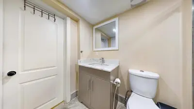 a bathroom with a toilet and a sink and a mirror at Landen court in Mississauga
