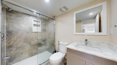 a bathroom with a shower and a toilet and a sink at Landen court in Mississauga