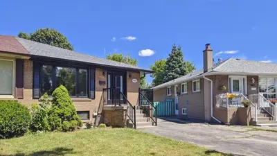 a brick house and a house with a driveway at Landen court in Mississauga