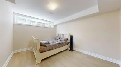 a bedroom with a bed in a room with a window at Landen court in Mississauga