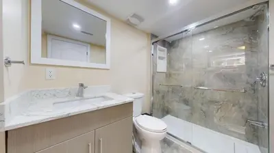 a bathroom with a shower and a toilet and a sink at Landen court in Mississauga