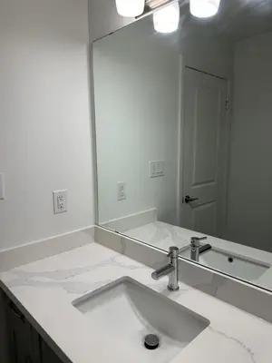 a bathroom with a sink and a large mirror at K Niagara Guesthouse in Niagara Falls