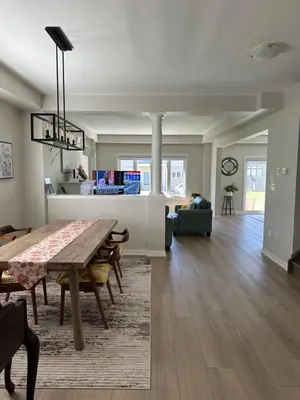 a dining room and living room with a wooden table at K Niagara Guesthouse in Niagara Falls