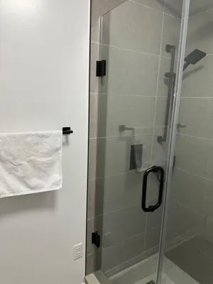 a shower with a glass door in a bathroom at K Niagara Guesthouse in Niagara Falls