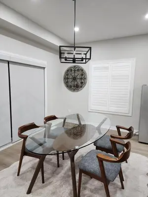 a dining room with a glass table and two chairs at K Niagara Guesthouse in Niagara Falls