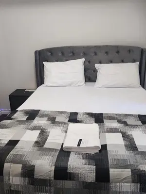 a bed with a black and white blanket on it at Kanp version shared Apartments Toronto in Toronto