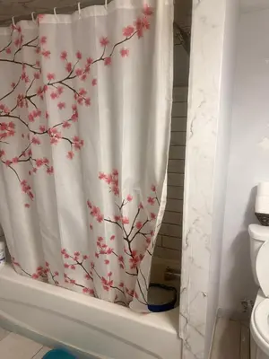 a bathroom with a shower curtain with a cherryossom pattern at Hespeler Haven Hideaway in Cambridge