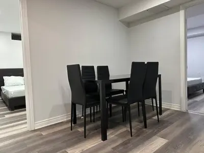 a black dining room table with black chairs in a room at New 2 bedroom basement in Cambridge in Cambridge