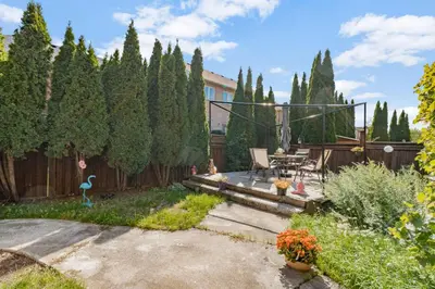 a backyard with a wooden fence and a patio at Comfortable Basement Private Room with Ensuite Near Plaza in Richmond Hill