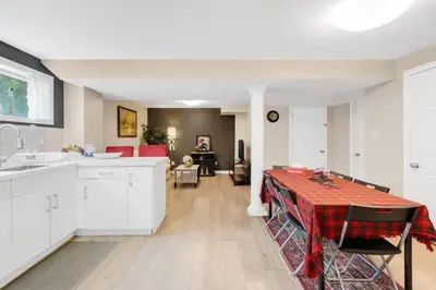 a kitchen with white cabinets and a table with a red table cloth at Comfortable Basement Private Room with Ensuite Near Plaza in Richmond Hill