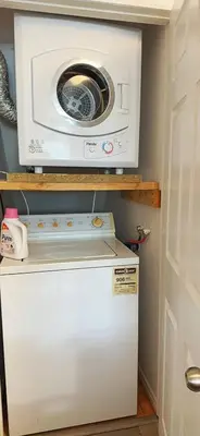 a washing machine sitting on top of a refrigerator at Comfortable Basement Private Room with Ensuite Near Plaza in Richmond Hill