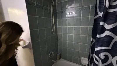 a woman standing in a bathroom with a shower at 3409 McDowell Drive Mississauga Ontario L5M6R7 in Mississauga