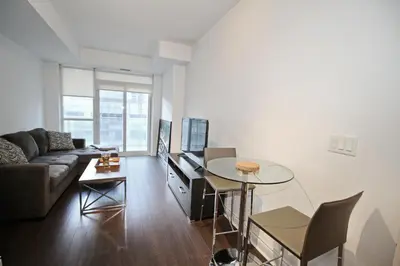 a living room with a couch and a table at The Grand Avenue Suites - Downtown Toronto Entertainment District in Toronto