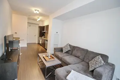 a living room with a couch and a table at The Grand Avenue Suites - Downtown Toronto Entertainment District in Toronto