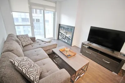 a living room with a couch and a flat screen tv at The Grand Avenue Suites - Downtown Toronto Entertainment District in Toronto