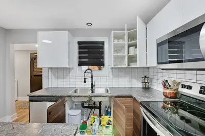 a kitchen with white cabinets and a sink at Welcome To Our Modern 2Bdrm,1Bth w, Laundry,BBQ in Welland