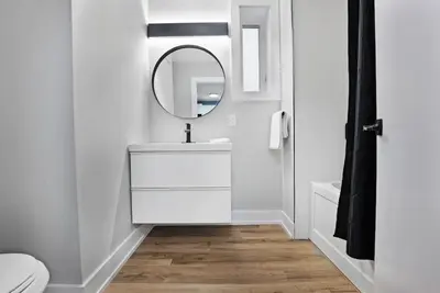 a white bathroom with a sink and a mirror at Welcome To Our Modern 2Bdrm,1Bth w, Laundry,BBQ in Welland