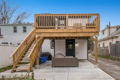 a large wooden deck with a couch under it at Welcome To Our Modern 2Bdrm,1Bth w, Laundry,BBQ in Welland