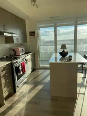 a kitchen with a stove and a counter with a table at Modern Private Room with Ensuite in Vaughan