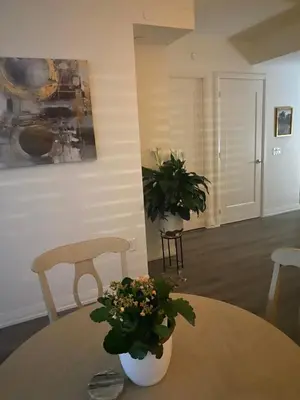 a table with two chairs and a table with flowers on it at Modern Private Room with Ensuite in Vaughan