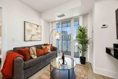 a living room with a couch and a glass table at Condo by CN Tower & Rogers Centre in Toronto