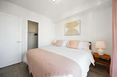a white bedroom with a bed and a table at Condo by CN Tower & Rogers Centre in Toronto