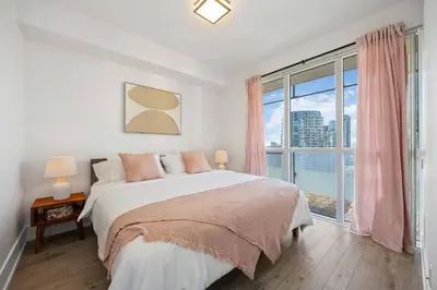 a bedroom with a bed and a large window at Condo by CN Tower & Rogers Centre in Toronto