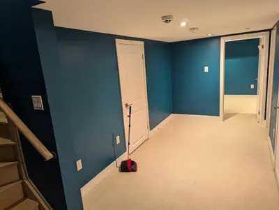 a hallway with blue walls and a mop in a room at Sunshine room on Downsview in Toronto