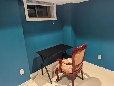 a desk and a chair in a room with blue walls at Sunshine room on Downsview in Toronto