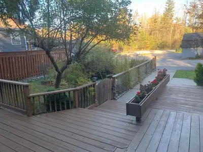 a wooden deck with flowers in a planter at 3 BDR lake Simcoe cottage-free parking -day pass to provincial park-one hour from Toronto in Georgina