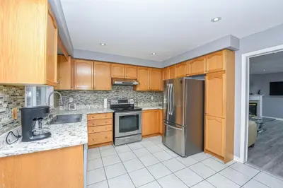 a kitchen with wooden cabinets and stainless steel appliances at Entire 4BR 3BA Home in Mississauga, Sleeps 8, 10 mins to Pearson Airport in Mississauga