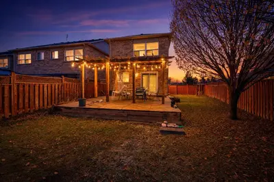 a house with a deck in front of a fence at Entire 4BR 3BA Home in Mississauga, Sleeps 8, 10 mins to Pearson Airport in Mississauga