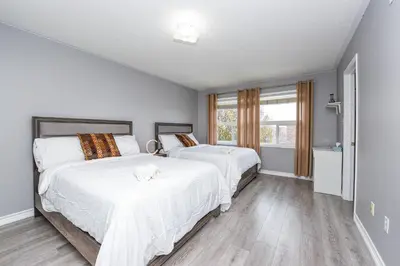 a bedroom with two beds and a window at Entire 4BR 3BA Home in Mississauga, Sleeps 8, 10 mins to Pearson Airport in Mississauga