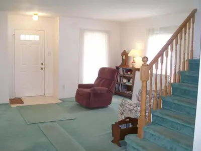a living room with a chair and a stair case at Lakeshore North - Waterloo, Ontario in Waterloo