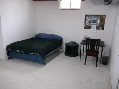 a small bedroom with a bed and a table at Lakeshore North - Waterloo, Ontario in Waterloo