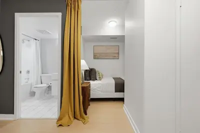 a bedroom with a bed and a bathroom with a shower at Upscale King Suite Near CN Tower with Free Parking in Toronto