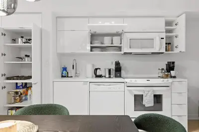 a kitchen with white appliances and a table and chairs at Upscale King Suite Near CN Tower with Free Parking in Toronto