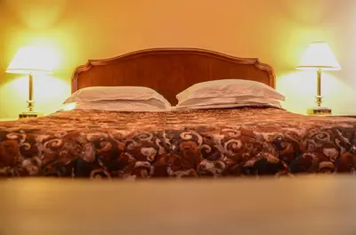 a bedroom with a bed with two lamps on it at Meaford Inn in Meaford
