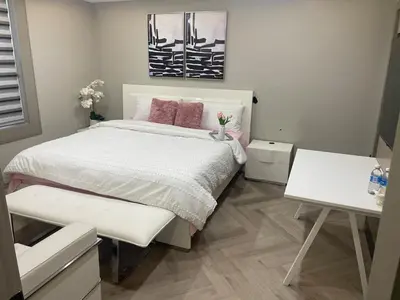 a bedroom with a white bed with pink pillows at Modern 7 Bedroom Masterpiece on Portage Sleeps 16 in Niagara Falls