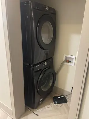 a washer and dryer in the corner of a room at Modern 7 Bedroom Masterpiece on Portage Sleeps 16 in Niagara Falls