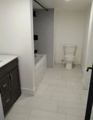 a bathroom with a tub and a toilet and a sink at Forest city family style furnished rooms in London