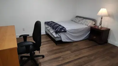 a bedroom with a bed and a desk with a chair at Forest city family style furnished rooms in London