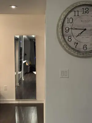 a clock hanging on a wall next to a mirror at Skyline Suite 1-Bed Penthouse in heart of Downtown Toronto in Toronto
